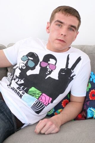 Horny twink Tom Jackson jerks his hard cock until he ejaculates on the couch