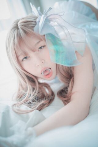 Saucy South Korean girl posing seductively in her white dress and stockings