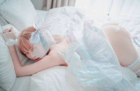 Saucy South Korean girl posing seductively in her white dress and stockings