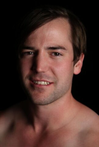 Good-looking gay Ethan shows off his athletic naked body and his hairy cock
