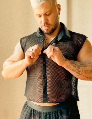 Male bodybuilder with short blonde hair displays his chiseled torso