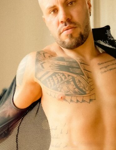 Male bodybuilder with short blonde hair displays his chiseled torso