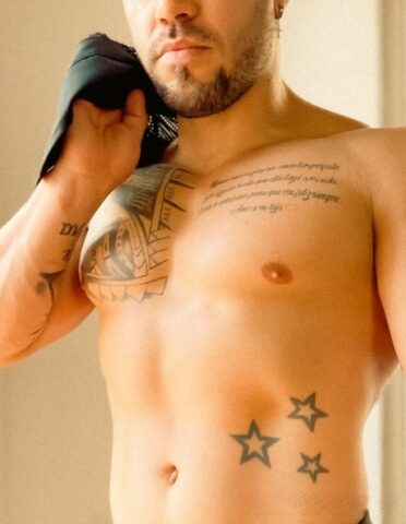 Male bodybuilder with short blonde hair displays his chiseled torso