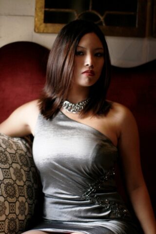 Breathtaking Asian teen Zoey Jones posing in her sexy dress on the sofa
