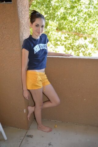 86951539_008_ca3e Petite amateur babe teases with her big ass in yellow shorts on the balcony