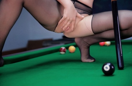 Pretty Asian babe flaunts her hot ass in a sexy striptease while playing pool