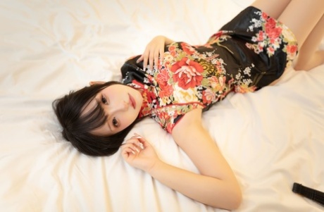 Asian wife sex doll shows her feet and flashes her upskirt on her bed
