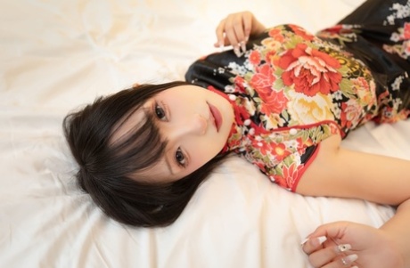 Asian wife sex doll shows her feet and flashes her upskirt on her bed