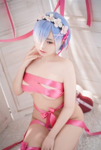 Beautiful Asian model with big tits poses while wrapped in pink satin ribbon
